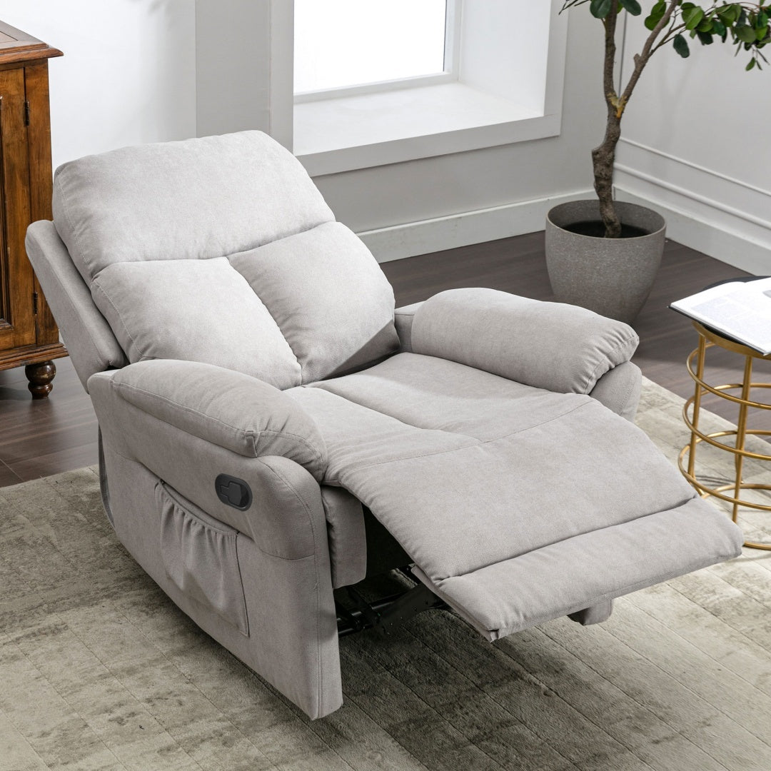 Gray recliner chair in a living room setting with a plant and table. 24bizhub